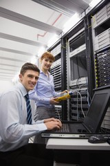 Poster - Team of technicians using digital cable analyser on servers
