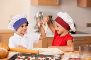 little children making bakery and smiling.