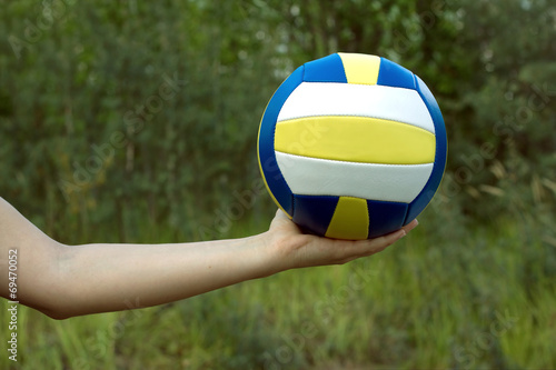 Naklejka samoprzylepna Ręka trzyma w dłoni piłkę sportową do gry w siatkówkę