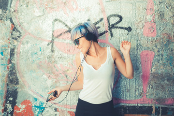 young beautiful short blue hair hipster woman with headphones mu