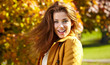 © ZoomTeam - Beautiful elegant woman standing in a park in autumn