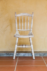 white Vintage chair near yellow old wall