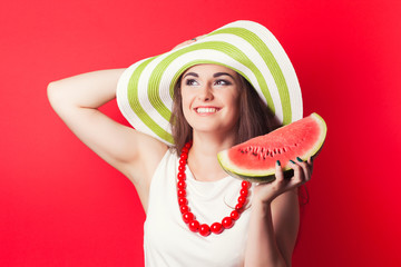 beautiful young woman holding watermelon against red background