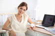 © lenets_tan - Attractive woman sitting at desk in office, working with laptop