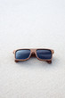 wooden sunglasses lying on the sand