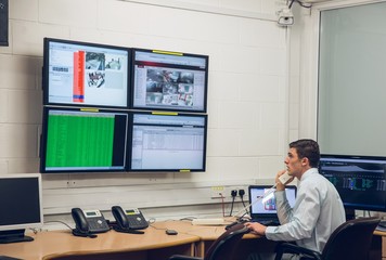 Poster - Technician sitting in office running diagnostics
