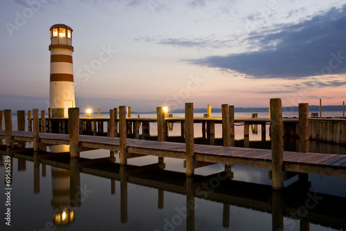 Obraz w ramie Am See mit Leuchtturm bei Sonnenuntergang