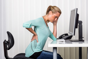 Frau mit Rückenschmerzen im Büro