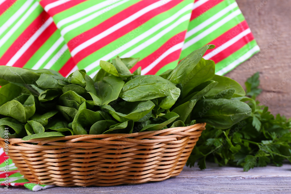 Fresh sorrel in round wicker basket on wooden background