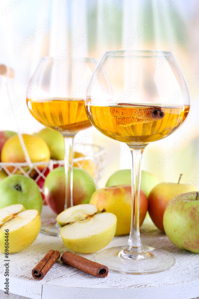 still life with apple cider and fresh apples on wooden table