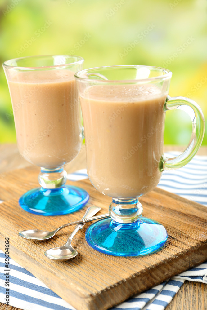 Delicious berry mousse in glasses on table on bright background