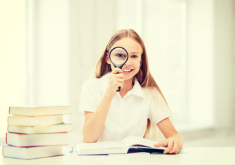 Canvas Print - girl reading book with magnifier at school