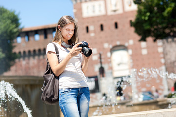 Wall Mural - Smiling female tourist taking photos