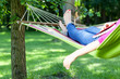 Lady lying with book on hammock
