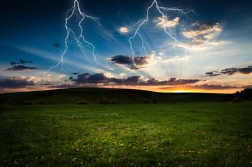 Wall Mural - thunderstorm with lightning in green meadow