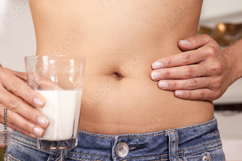 Fotografie, Obraz Frau haltet Glas mit Milch, einer Hand auf dem Bauch