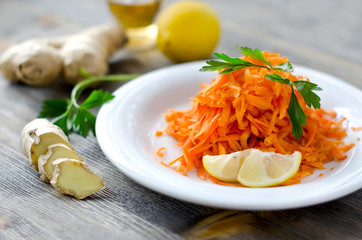 Fresh carrot salad with ginger and lemon on a plate