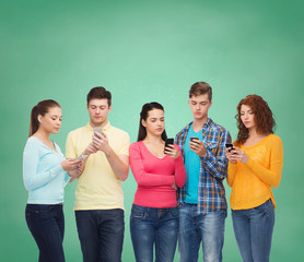 Canvas Print - group of serious teenagers with smartphones