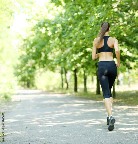 Board z aluminiowym obramowaniem Młoda kobieta jogging w parku