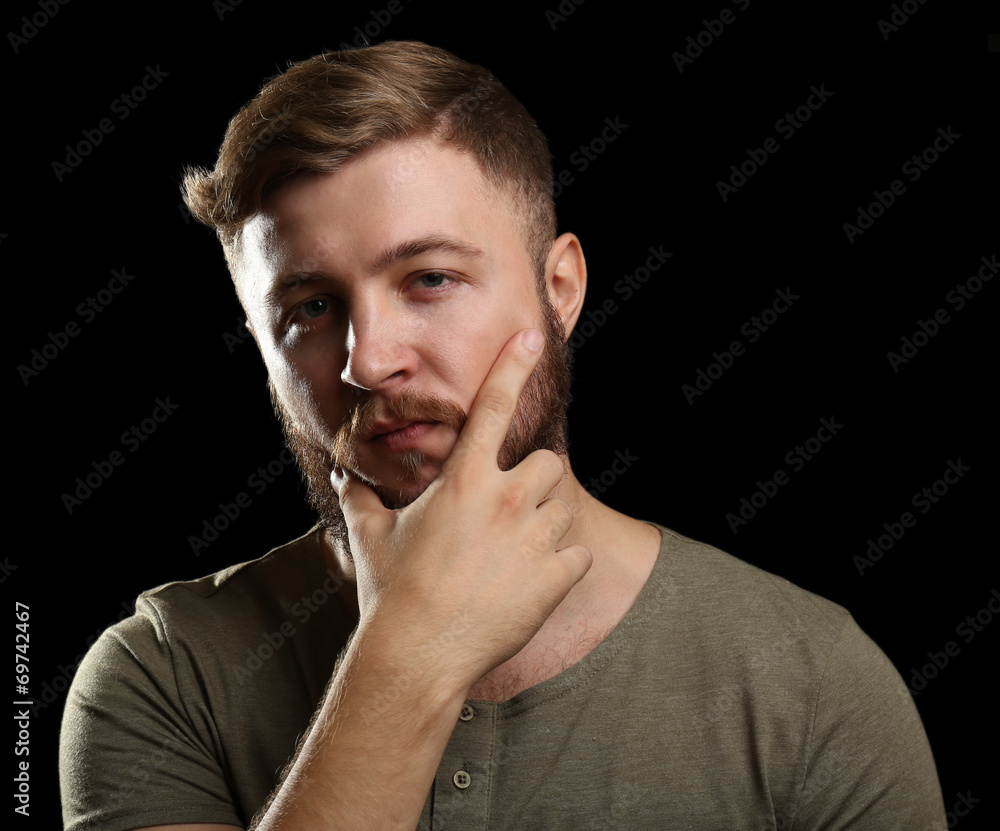 Portrait of handsome man with beard on black background