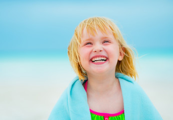 Wall Mural - Portrait of baby girl in towel on beach