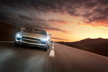 Luxury Sports Car Speeding On Empty Highway At The Sunset