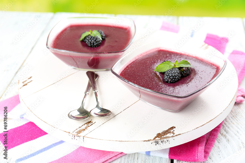 Delicious berry mousse in bowls on table close-up