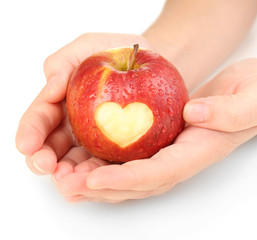 Wall Mural - Red apple with heart in hands isolated on white