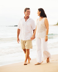 Wall Mural - Mature Couple Enjoying Sunset on the Beach