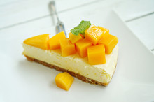 Mango Cheesecake On White Plate With Fork