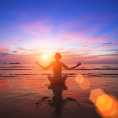 Wall Mural - Girl practicing yoga on the ocean side