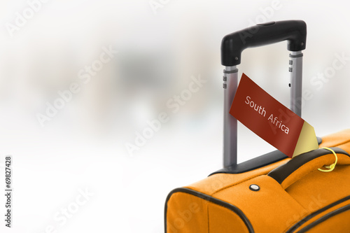 Fotografija South Africa. Orange suitcase with label at airport.