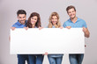 © Viorel Sima - casual group of young people holding a big blank board