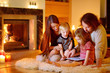 © MNStudio - Happy family using a tablet pc by a fireplace