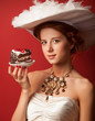 © Masson - Portrait of redhead edwardian women with cake on red background.