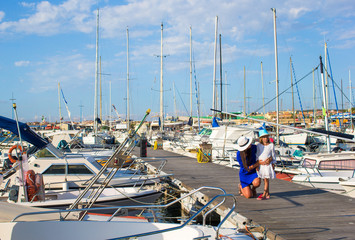 Young mother with little girl in the port enjoying summer day