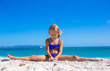 Adorable Little Girl Making Leg-split On Tropical White Sandy