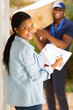 © michaeljung - black woman signing document for receiving package