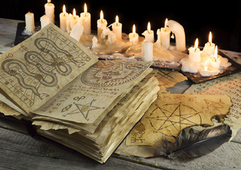 Grimoire book with candles and magic papers