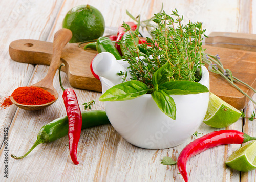 Fototapeta na wymiar Mortar with herbs and chili peppers