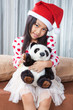 © Mckyartstudio - smiling girl in santa helper hat with teddy bear