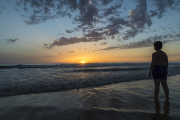 boy bathing on the beach at dusk