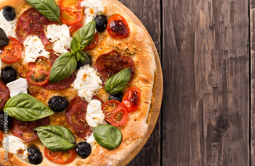 Naklejka samoprzylepna Pizza z salami i mozzarellą widok z góry z miejsca na kopię rustykalne