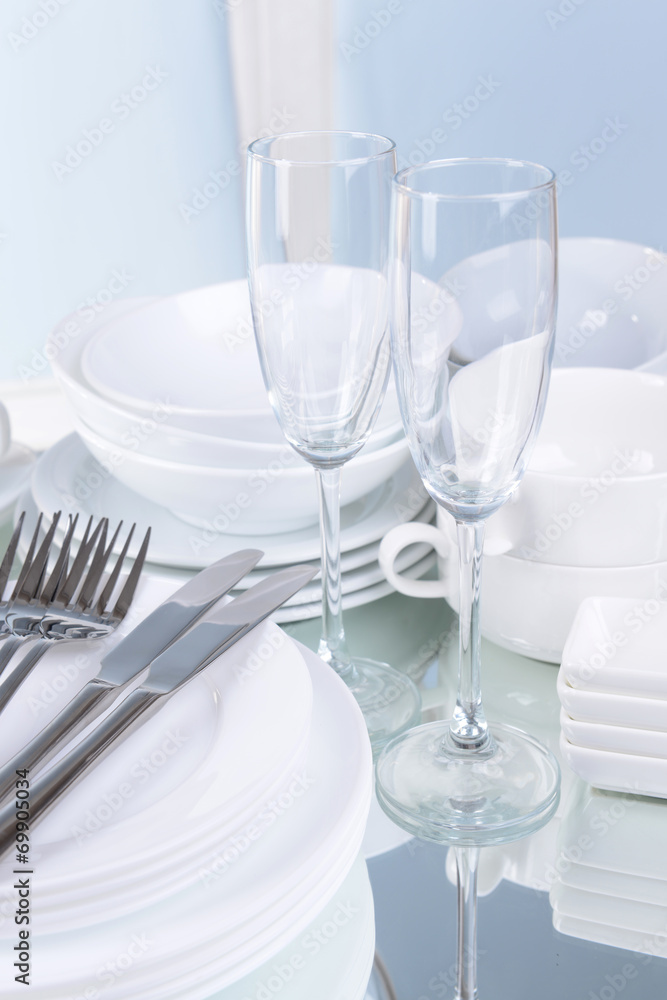 Set of white dishes on table on light background
