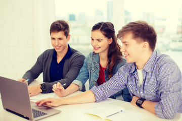 Wall Mural - three smiling students with laptop and notebooks