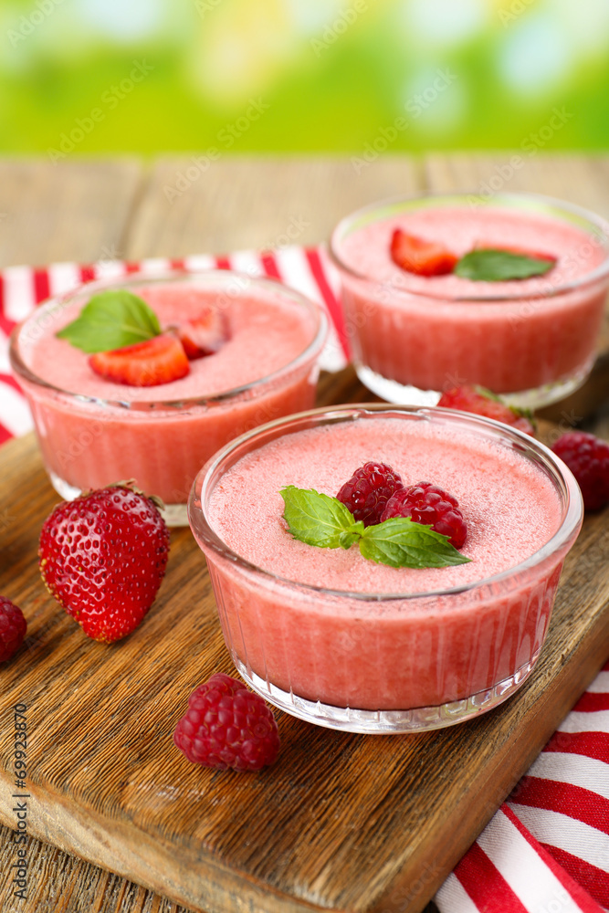 Delicious berry mousse in bowls on table close-up