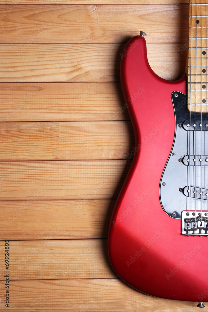 Red guitar on wooden background