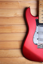 Red Guitar On Wooden Background