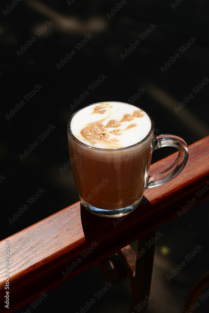 Cup of coffee with cute drawing in cafe