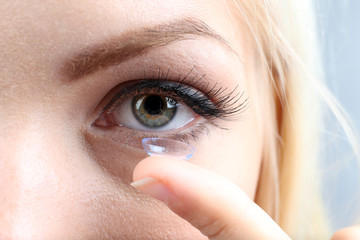 Wall Mural - Medicine and vision concept - young woman with contact lens,